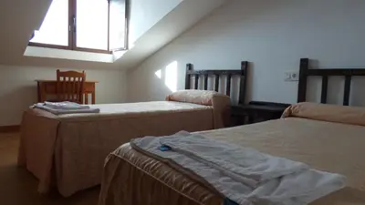 a hotel room with two beds and a window at Convento de Foncebadon in Foncebadón