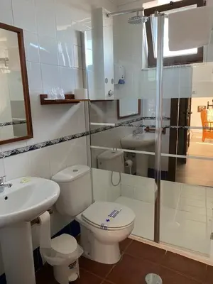 a white bathroom with a toilet and a sink at Convento de Foncebadon in Foncebadón