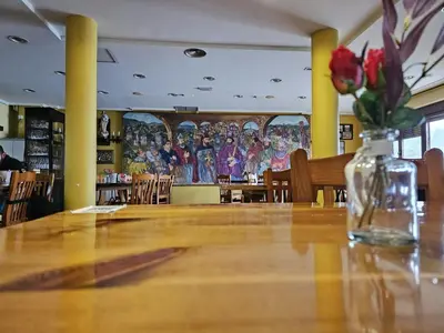 a table in a restaurant with a vase of flowers on it at Convento de Foncebadon in Foncebadón