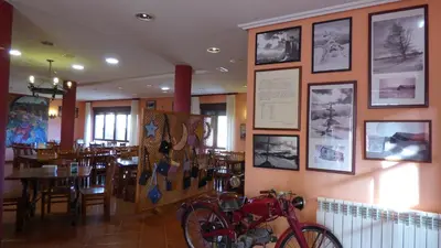 a restaurant with a bike on a wall with pictures at Convento de Foncebadon in Foncebadón
