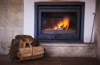 a fireplace with a basket in front of it at Casa Cruceiro in Barcela