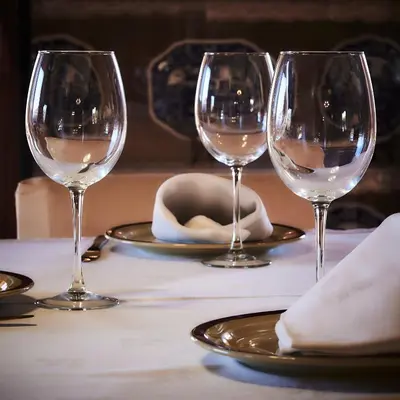 three wine glasses sitting on a table with plates at Casa Cruceiro in Barcela