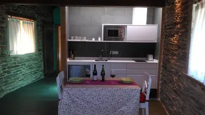 a kitchen with a table with two bottles of wine at Casa Do Grilo in Monfero