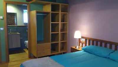 a bedroom with a bed and a large wooden cabinet at Casa Do Grilo in Monfero