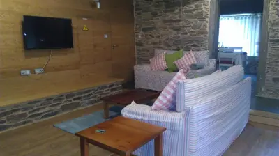 a living room with a couch and a tv at Casa Do Grilo in Monfero