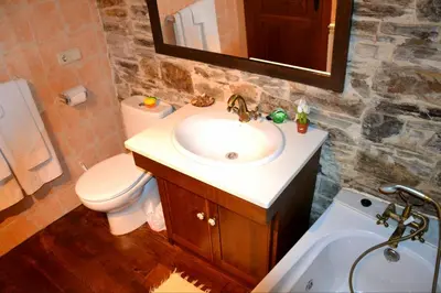 a bathroom with a sink and a toilet and a mirror at Apartamento La Corrada in Santa Eulalia de Oscos