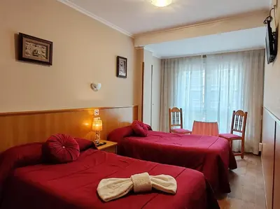 a hotel room with two beds with a ribbon on them at Hostal Ponte Dos Santos in Ribadeo