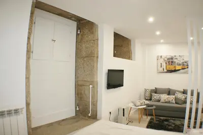 a living room with a couch and a tv at Apartamentos Pombal in Santiago de Compostela
