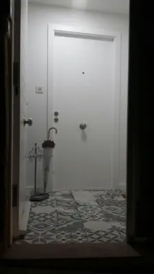 a white door with a tile floor in a hallway at Apartamentos Pombal in Santiago de Compostela