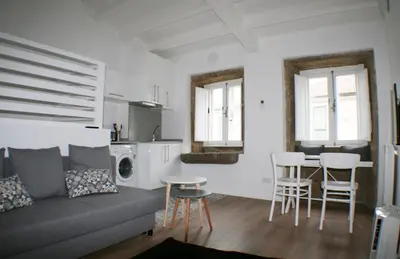 a living room with a couch and a table and chairs at Apartamentos Pombal in Santiago de Compostela