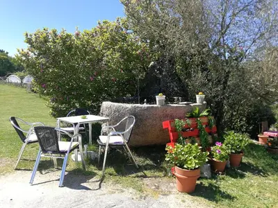a table and chairs and a table and some plants at Caserio de Fontes in Nogueira de Ramuin