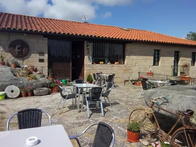 a patio with tables and chairs in front of a building at Caserio de Fontes in Nogueira de Ramuin