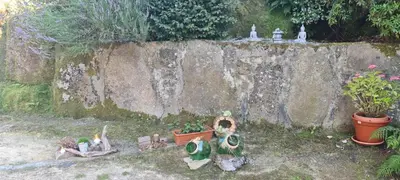 a group of figurines sitting next to a wall at Caserio de Fontes in Nogueira de Ramuin