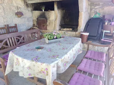 a table and chairs with a table and flowers on it at Caserio de Fontes in Nogueira de Ramuin