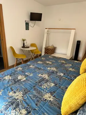 a bedroom with a bed with a blue and white bedspread at El Malecon in Sarria