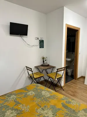 a bedroom with a bed and two chairs and a table at El Malecon in Sarria