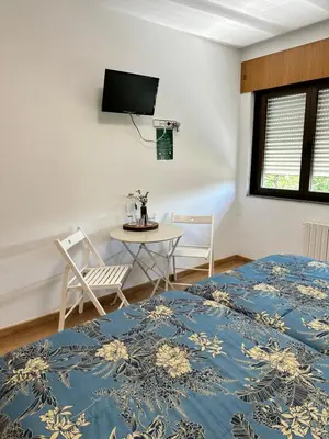 a room with a bed and a table and chairs at El Malecon in Sarria