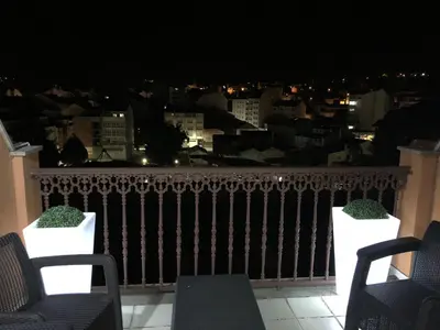 a balcony with chairs and a view of the city at night at High Rentxacobeo in Sarria