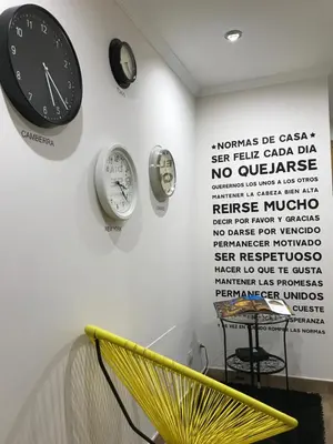 a room with clocks on the wall and a yellow bench at High Rentxacobeo in Sarria