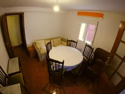 a room with a table and chairs and a couch at Alojamientos turísticos VUT-LE-043 in Villablino