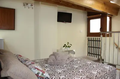 a bedroom with a bed and a tv on the wall at Casa Do Medio in Santiago de Compostela