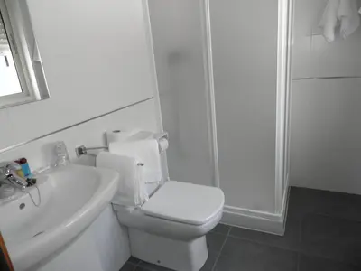 a white bathroom with a toilet and a sink at Pension Restaurante La Bombilla in A Estrada