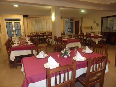a dining room with red and white tables and chairs at Pension Restaurante La Bombilla in A Estrada