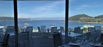 a view of the ocean from a restaurant with tables and chairs at Hotel Ego in Viveiro