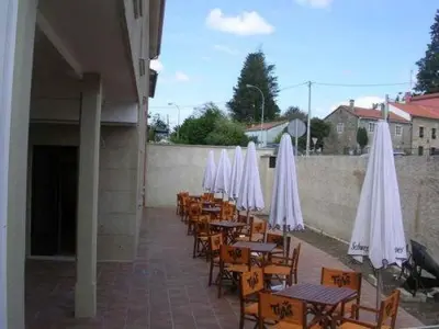 a row of tables and chairs with white umbrellas at Hotel O Desvio in Santiago de Compostela