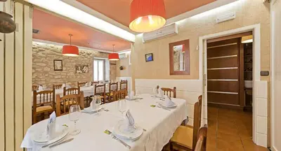 a dining room with a table with white tablecloths and chairs at Hotel O Desvio in Santiago de Compostela