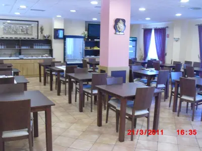 a dining room with wooden tables and chairs at Hotel O Desvio in Santiago de Compostela