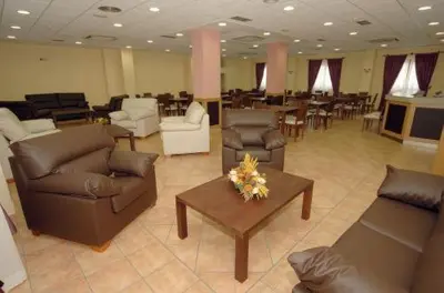 a living room with couches and a table with flowers at Hotel O Desvio in Santiago de Compostela