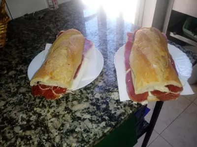 two hot dogs on paper plates on a counter at Casa Quiroga in Lamas