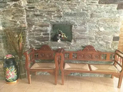 a wooden bench sitting in front of a stone wall at Casa Quiroga in Lamas