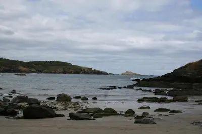 a beach with rocks and the ocean on a cloudy day at Casa Tésera in El Franco