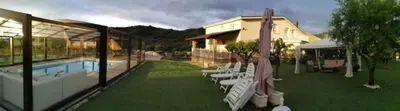 a resort with a pool and chairs and a building at Casa Rural Elias in Molinaseca