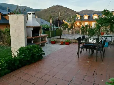 a patio with a table and chairs and a fireplace at Casa Rural Elias in Molinaseca