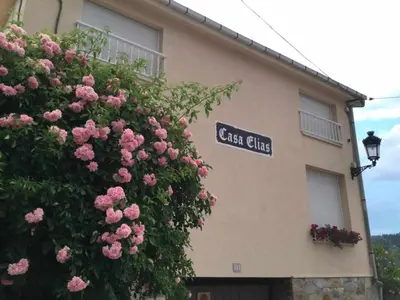 a building with a bush of pink flowers in front of it at Casa Rural Elias in Molinaseca
