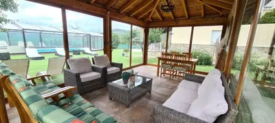 a screened in porch with couches and chairs and a table at Casa Rural Elias in Molinaseca