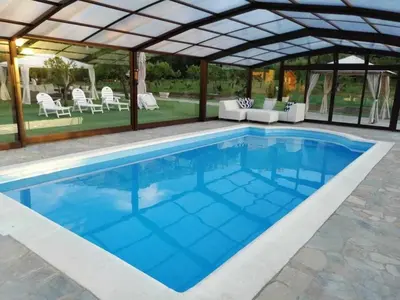 a large swimming pool with a pergola and a swimming pool at Casa Rural Elias in Molinaseca
