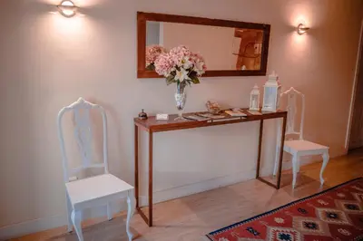 a table with two chairs and a vase of flowers at Hostal Camponaraya in Camponaraya