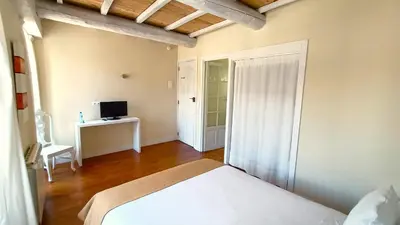 a bedroom with a bed and a desk with a television at Hostal Camponaraya in Camponaraya