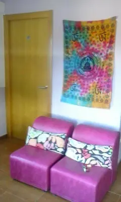 a purple couch in a room with a painting at Albergue o Apalpador in Melide