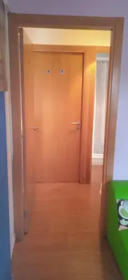 a hallway with two wooden doors in a room at Albergue o Apalpador in Melide