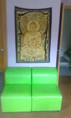 a green bench in front of a picture of a statue at Albergue o Apalpador in Melide