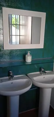 a bathroom with two white sinks and a mirror at Albergue o Apalpador in Melide