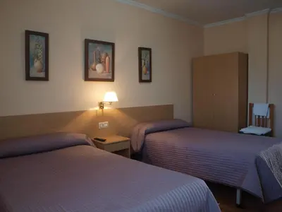 a hotel room with two beds and a lamp at Pensión HK in A Angueira de Suso