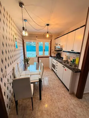 a kitchen with a couch and a table and chairs at Apartamentos Portolux in Portomarin