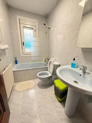 a bathroom with a sink and a toilet and a tub at Apartamentos Portolux in Portomarin