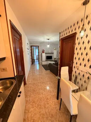 a kitchen with a sink and a living room at Apartamentos Portolux in Portomarin